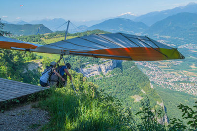 Man sitting on mountains against sky