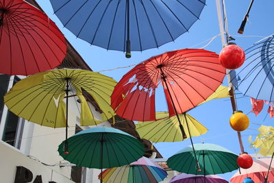 Low angle view of umbrellas hanging against clear sky