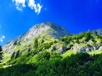 Low angle view of mountain against blue sky