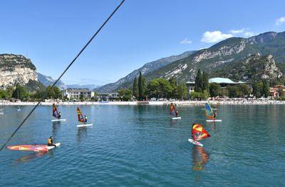 People on boat in lake against sky