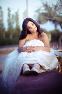 Beautiful young woman sitting outdoors