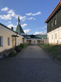 Street amidst buildings in town against sky