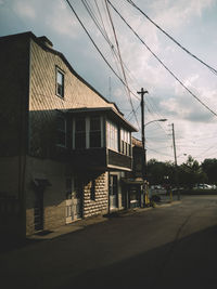 Houses by road against sky