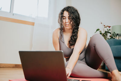 Overweight woman using laptop at home