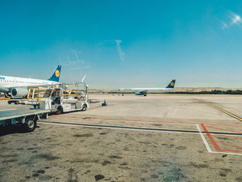 Airplane on airport runway against sky