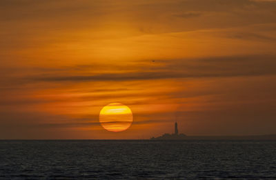 Scenic view of sea against orange sky