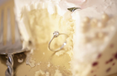 High angle view of diamond ring with wedding cake