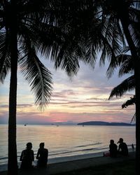 Silhouette people at beach during sunset