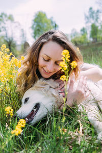 Young beautiful woman and her golden retriever dog having fun in summer