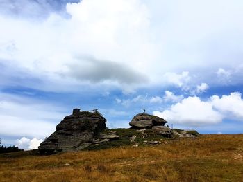 Rocks on field against sky