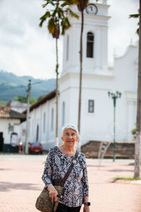 Senior adult woman at the central square in the city of guaduas. senior travel concept.