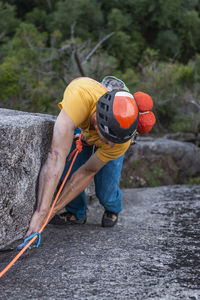 Rock climber looking at his feet while climbing multipitch route