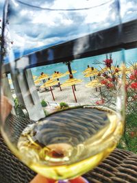 Beach umbrellas seen through wineglass