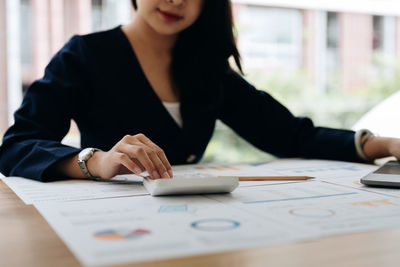 Midsection of businesswoman working at office