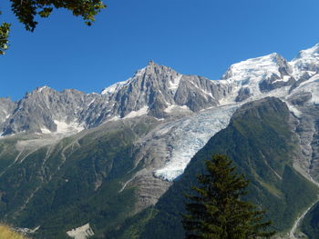 Scenic view of snowcapped mountains against clear blue sky