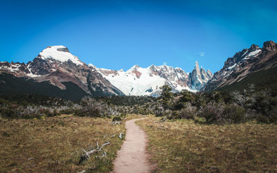 Scenic view of snowcapped mountains against clear blue sky