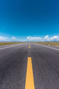 Surface level of road against blue sky