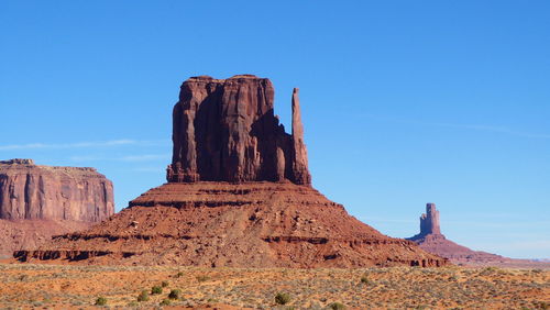 Monument valley rock formation against a clear blue sky