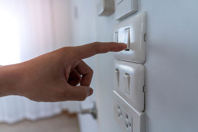 Close-up of human hand on wall at home