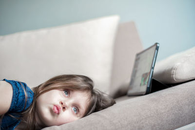 Portrait of cute girl lying down on sofa