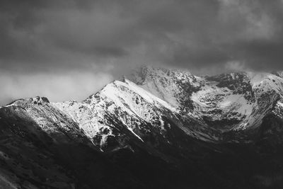 Low angle view of snowcapped mountains against sky