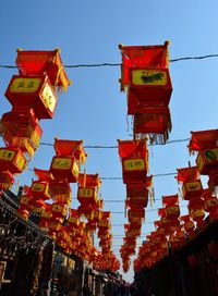 Low angle view of lanterns hanging against sky