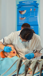 Rear view of doctor examining patient at clinic