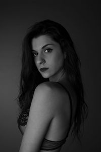 Portrait of a beautiful young woman over black background