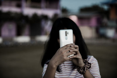 Midsection of woman using mobile phone