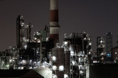 Illuminated factory against clear sky at night