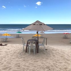 Deck chairs on beach against clear blue sky