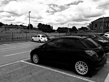 Cars on road in city against sky