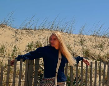 Young woman sitting against clear sky