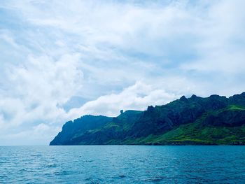 Scenic view of sea and mountains against sky