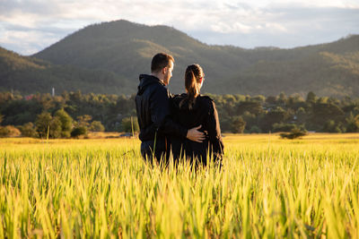 Couple standing at farm against mountains