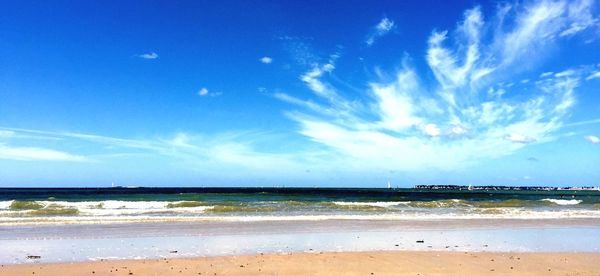 Scenic view of beach against blue sky