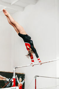 Woman performing gymnastic on bar