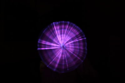 Close-up of illuminated lighting equipment against black background