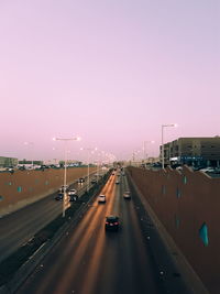 Cars on road in city against clear sky