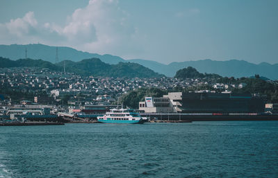 Scenic view of sea by buildings against sky