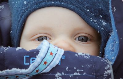 Close-up portrait of baby girl in snow