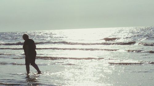 Man standing on beach against sky