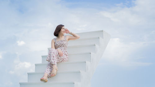 Low angle view of woman standing against sky