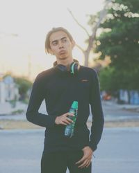 Portrait of young woman standing on road