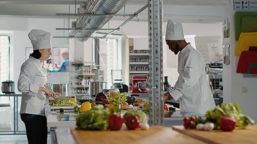 Chef working with trainee in kitchen