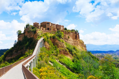 Built structure on mountain against cloudy sky