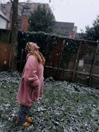 Full length of woman laughing while looking up outdoors