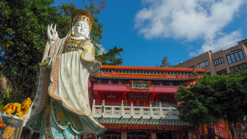Low angle view of statues on building against sky