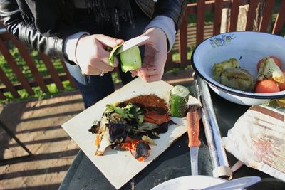 Midsection of woman holding food on table