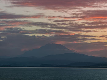 Scenic view of sea against dramatic sky during sunset